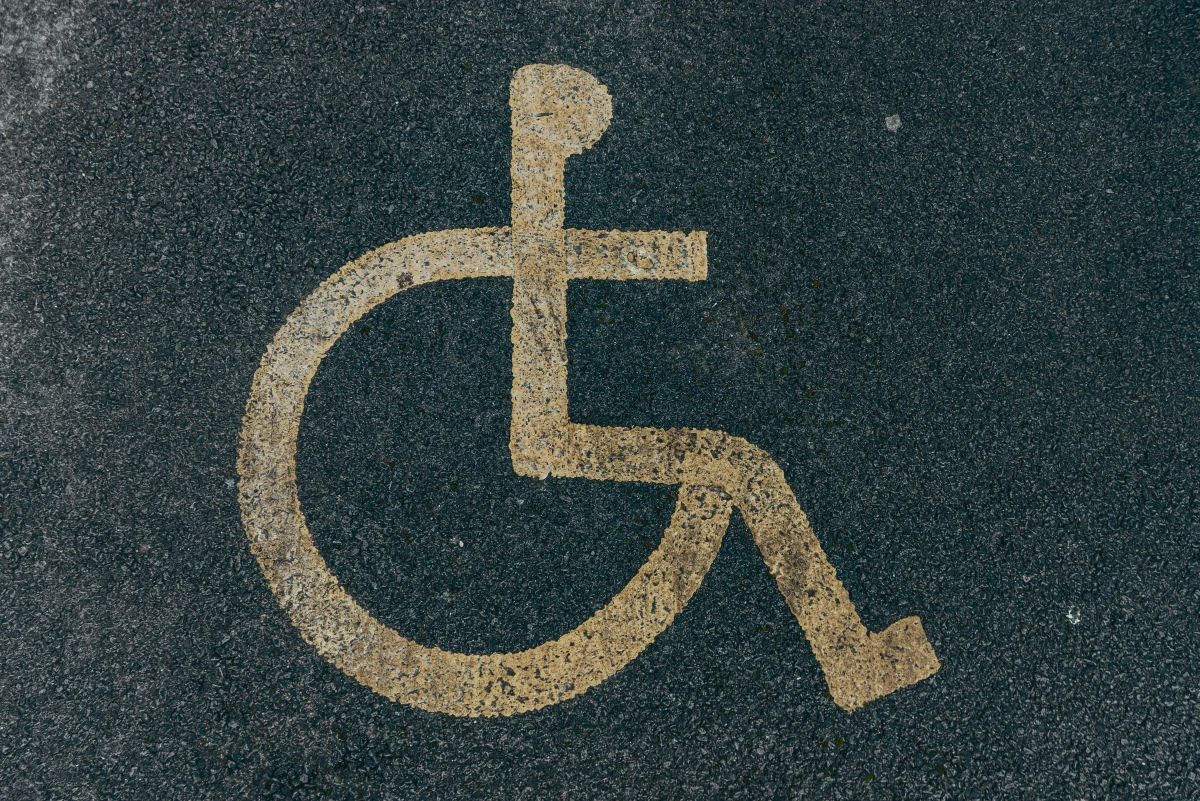 Accessible parking symbol painted on asphalt, representing accessibility at Kingdom Foundation College