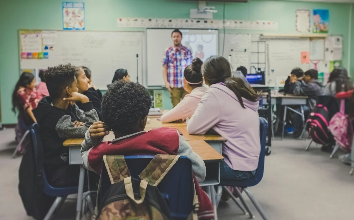 Diverse group of students listening to a teacher in a classroom